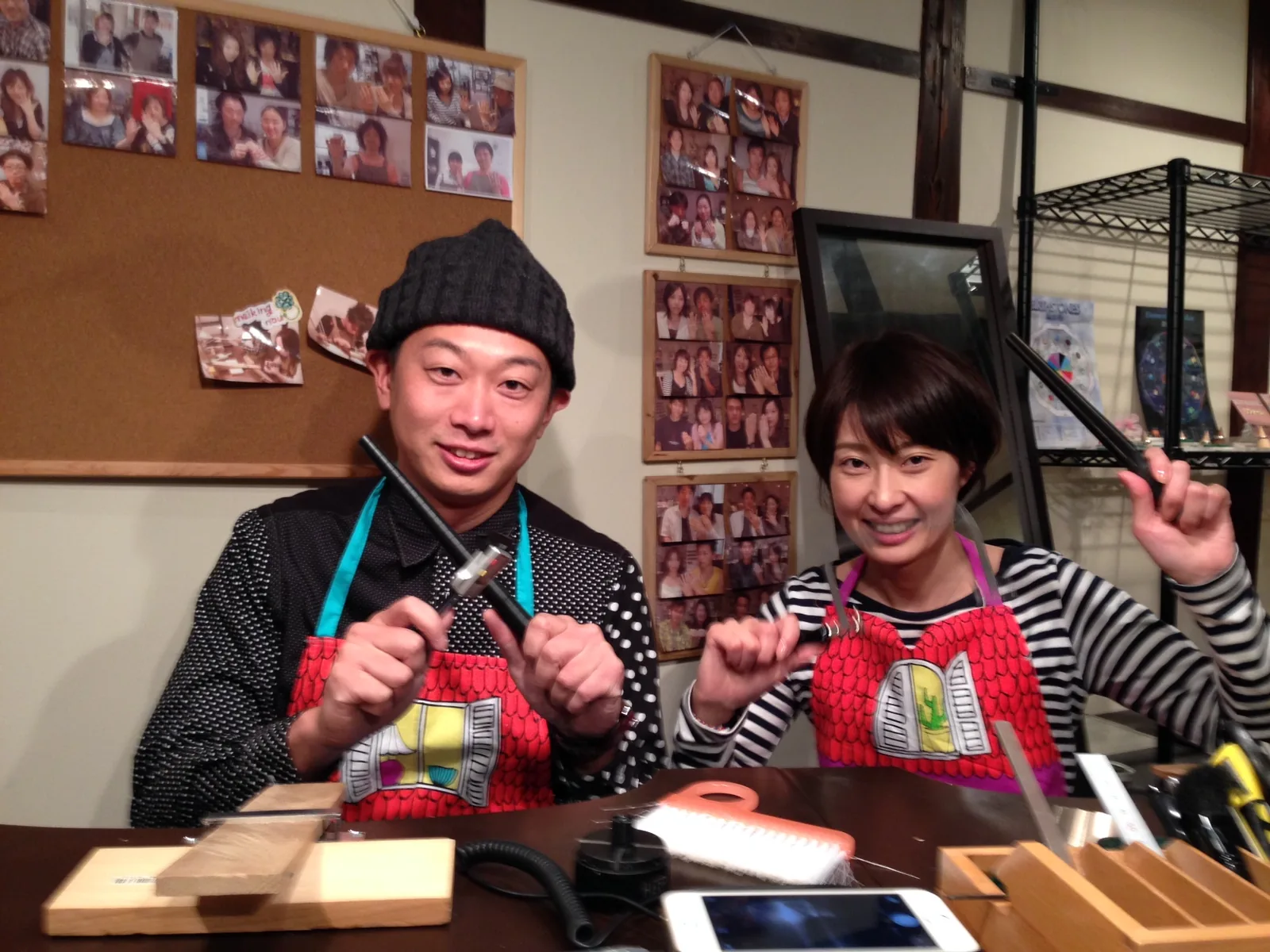 手作り結婚指輪の制作体験中、金槌などの工具を手に笑顔を見せるカップル。工房でふたりが指輪づくりを楽しむ様子