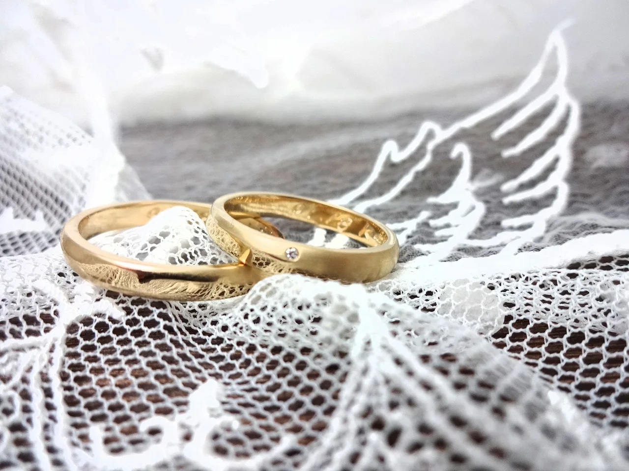 レースの上で撮影したイエローゴールドの手作り結婚指輪