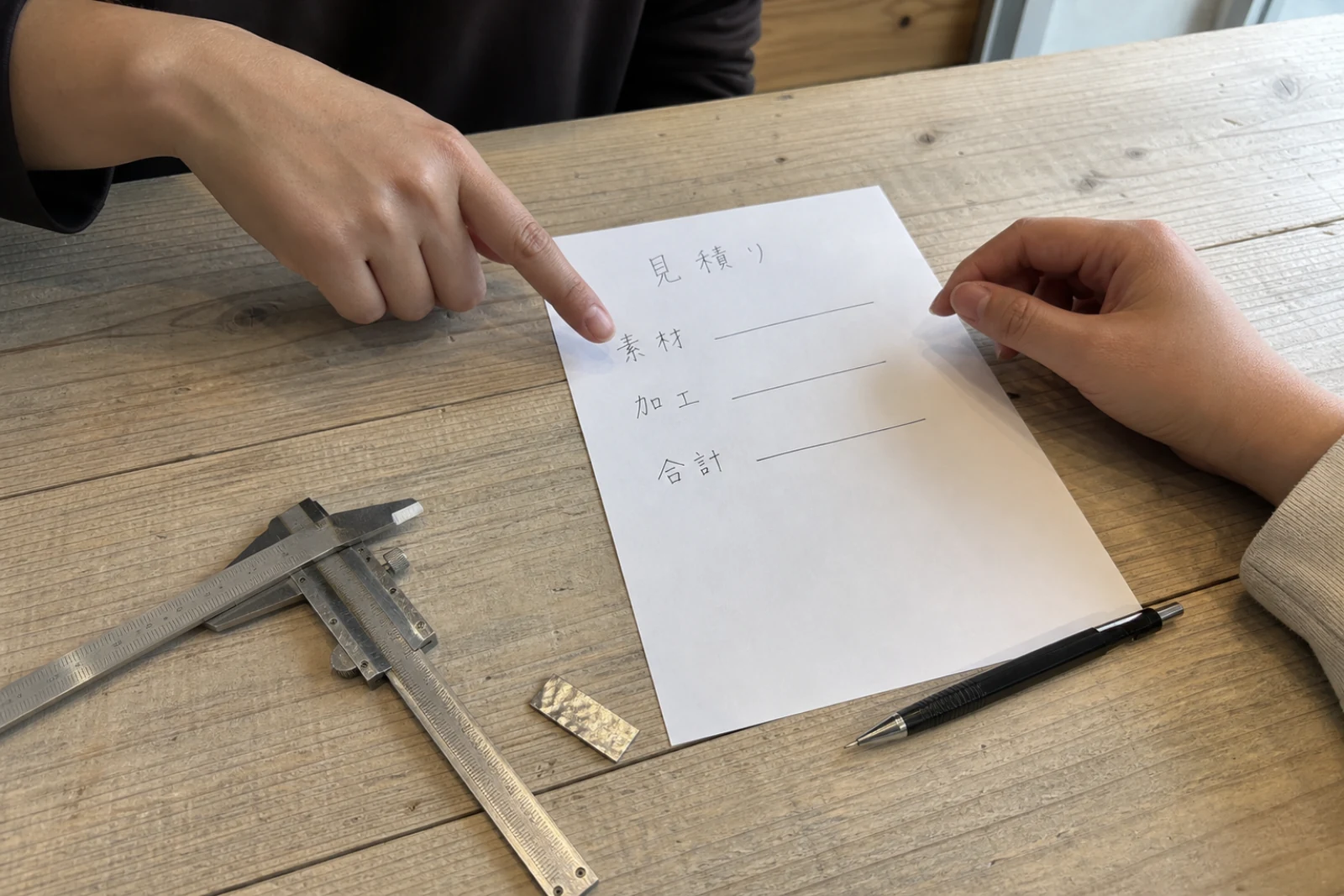 見積りの内訳を指しながら相談する手元（イメージ）